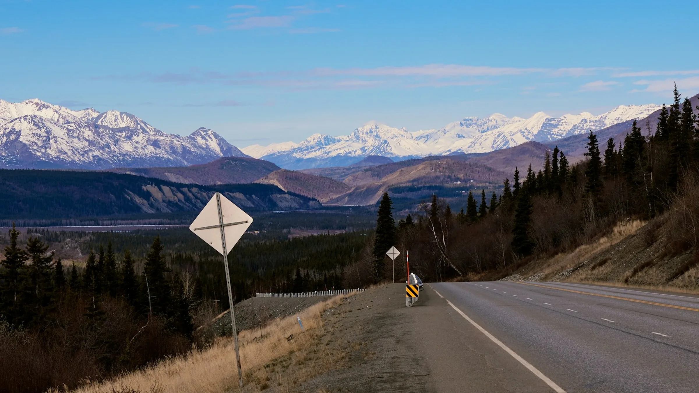 Mountain highway winding toward snow-capped peaks